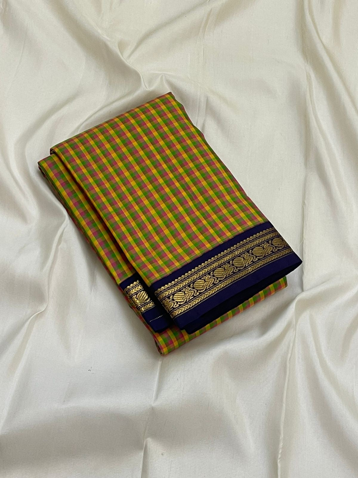 Forest Blossom Kattam — Pure Silk Kanchipuram Saree
Parrot-green, rani-pink & haldi-yellow kattam checks
Deep navy korvai borders with antique gold zari vines
Rich navy zari-striped pallu with tasseled edges
Silk Mark Cert • Free USA Shipping 1 week