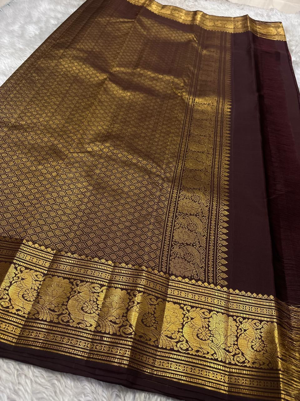 Sienna Red Mayuri Butta — Pure Kanchipuram Silk
Sienna-red body with zari mayuri buttas & antique gold border
Contrast coffee-brown pallu in rich zari jaal • Silk Mark Certified • Free USA Shipping