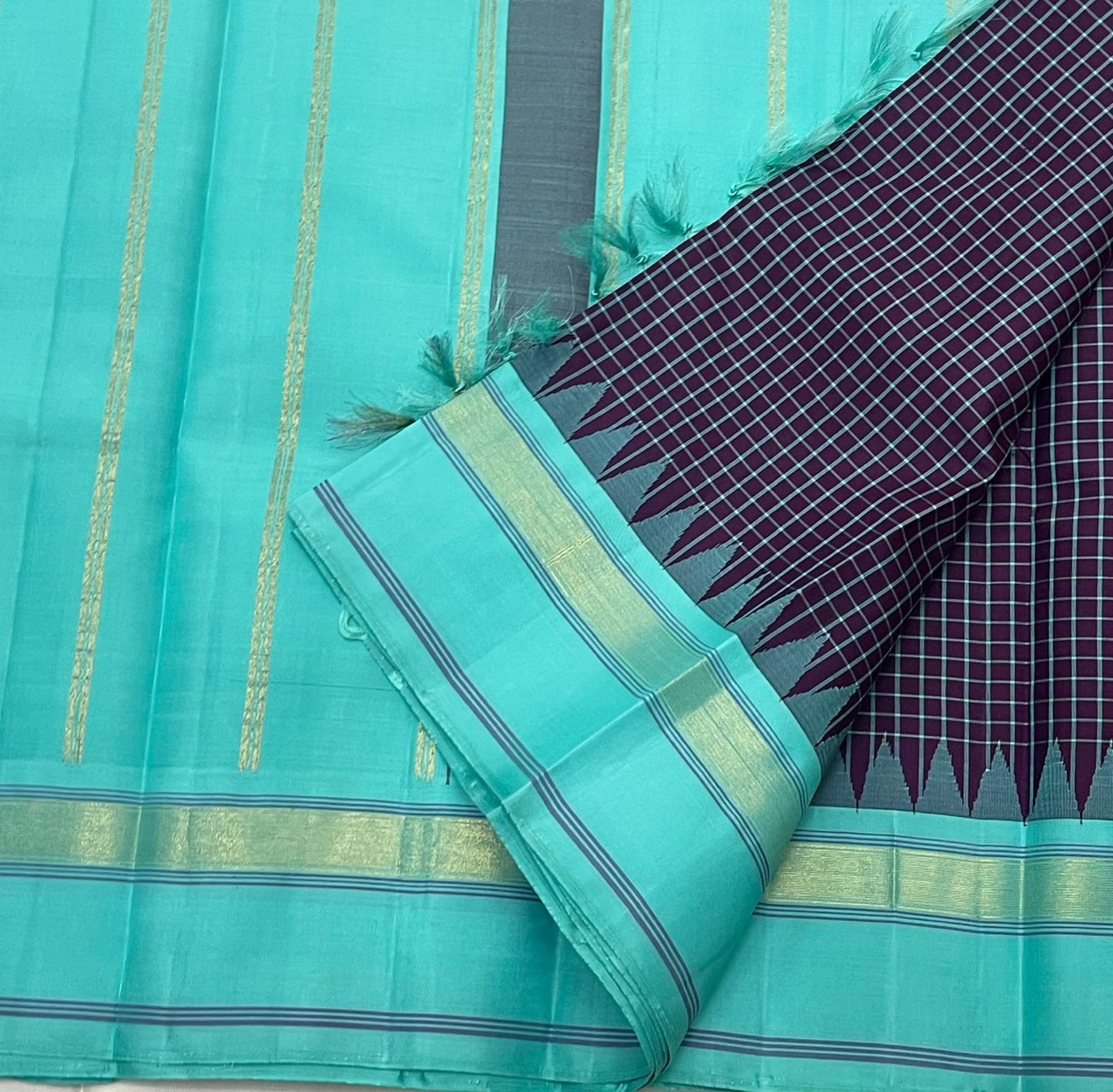 Pure Handwoven Kanchipuram Silk Saree – Deep Aubergine Body with Micro Checks
Contrasting Aqua Blue Korvai Borders with Temple Motifs & silk thread Stripes
Elegant Striped Aqua seer Pallu
Silk Mark Certified ✅ ships in 2 weeks.
