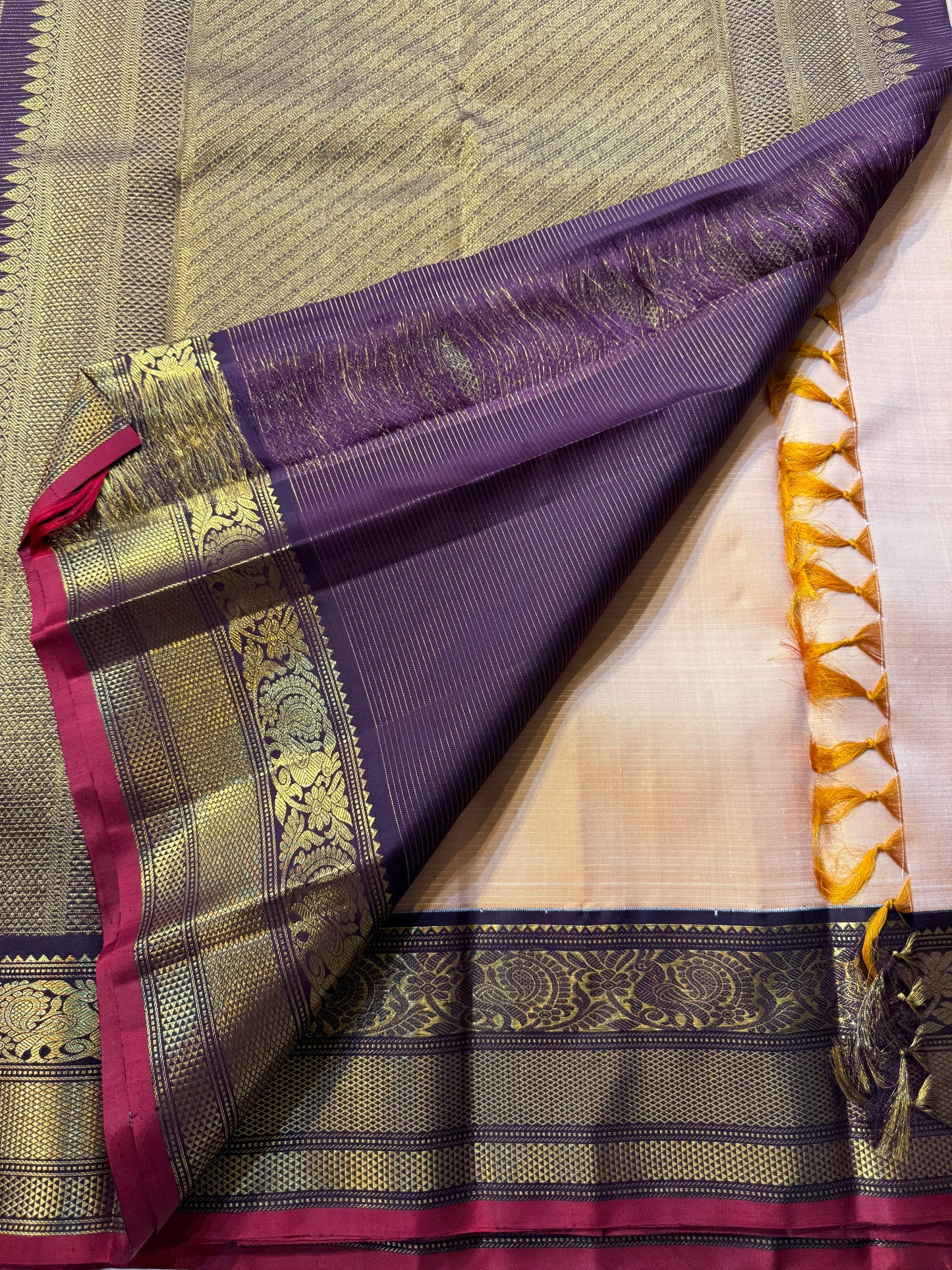 Sandhya ๐
โ Sun-Kissed Beige Kanchipuram Silk Saree with Subtle Vairaoosi Gold Filament โจ, Deep Purple Peacock Diamond-Pettu Zari Border ๐ฆ, Deep Maroon Selvedge, and Zari-Embellished Pallu with Arai Maadam & Khalasam Motifs ๐ฟ๐