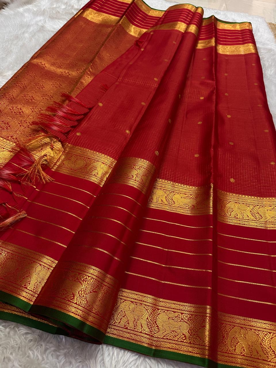 Kiran – Deep Red Kanchipuram Pure Silk Saree
Zari Checks with Delicate Buttas and Striped Rettapet Border
Richly Woven Pallu Accented by a bottle Green Selvedge