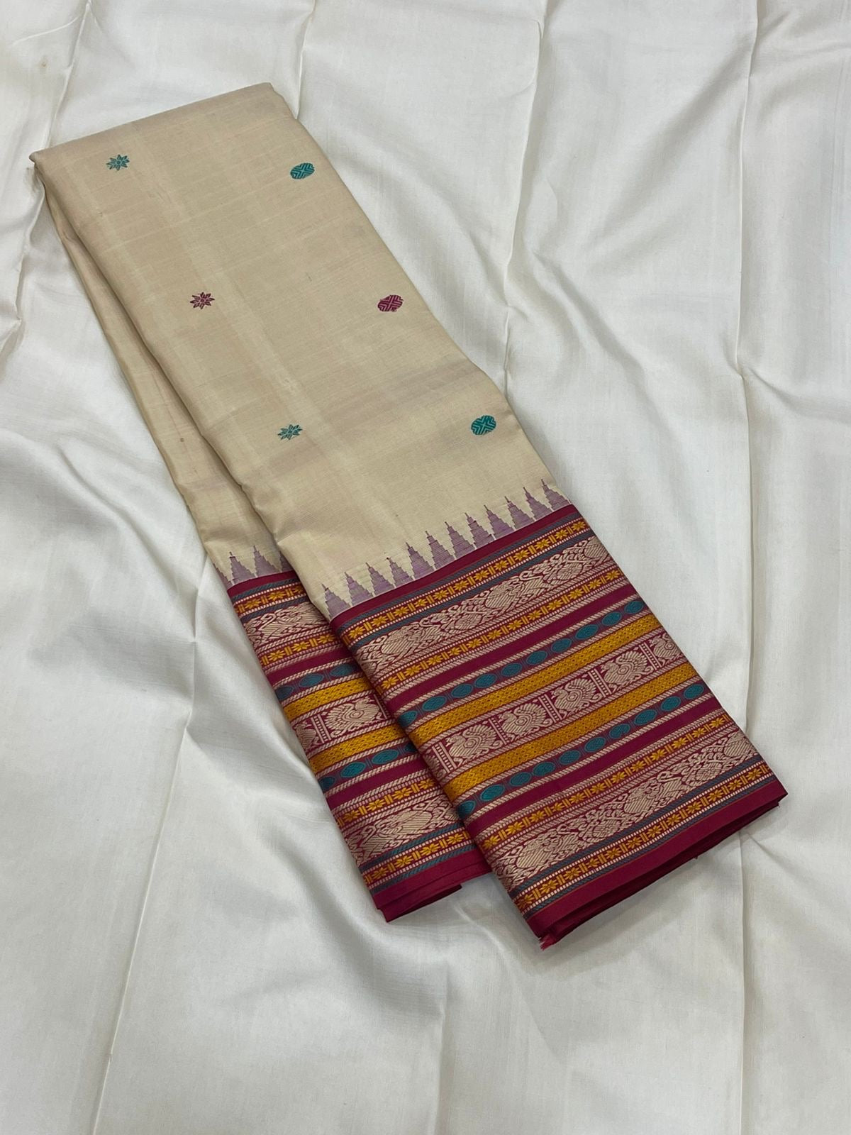 Pari Silk Thread Weaving — Pure Silk Kanchipuram
Ivory body with multi-color silk thread buttas (teal, wine & magenta)
Korvai contrast wine-magenta borders with vintage thread stripe panels
Temple gopuram inner edge & grand pallu in handwoven silk thread