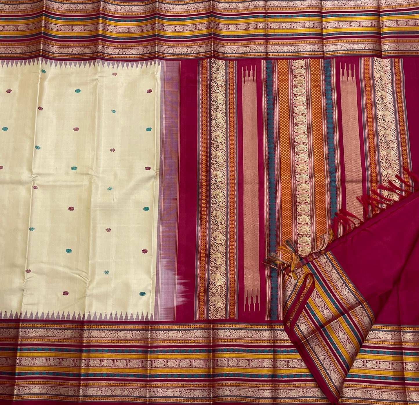 Pari Silk Thread Weaving — Pure Silk Kanchipuram
Ivory body with multi-color silk thread buttas (teal, wine & magenta)
Korvai contrast wine-magenta borders with vintage thread stripe panels
Temple gopuram inner edge & grand pallu in handwoven silk thread