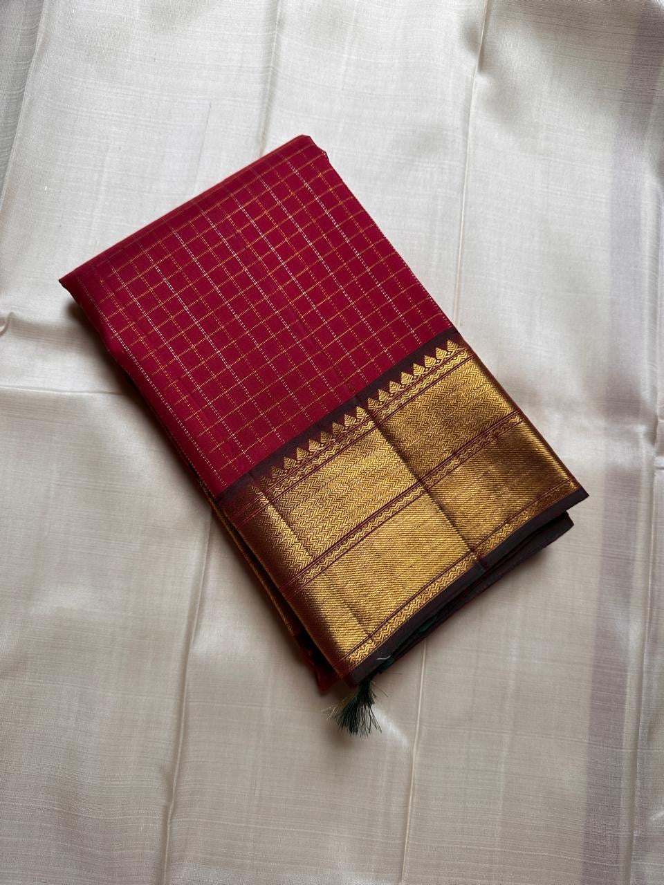 Ruby Zari Kattam – Pure Kanchipuram Silk Saree
Rich Ruby Red Body with Gold Zari Checks
Broad Golden Border with Maroon Highlights & Temple Motifs
Dual-Toned Maroon-Green Pallu with Intricate Zari Weaves
Silk Mark Certified, delivery in 2 weeks