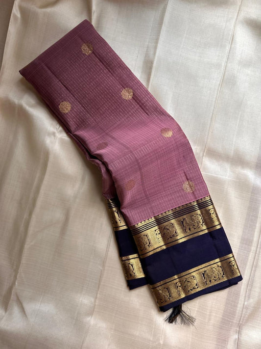 Midnight Blue & Mauve — Pure Silk Kanchipuram
Mauve body with pin-stripes & zari coin buttas ✨
Midnight-navy korvai borders with gaja panels 🌸
Grand navy brocade pallu with tassels 🪔
Silk Mark Certified • Free Shipping USA • Ships in Two Weeks ✅