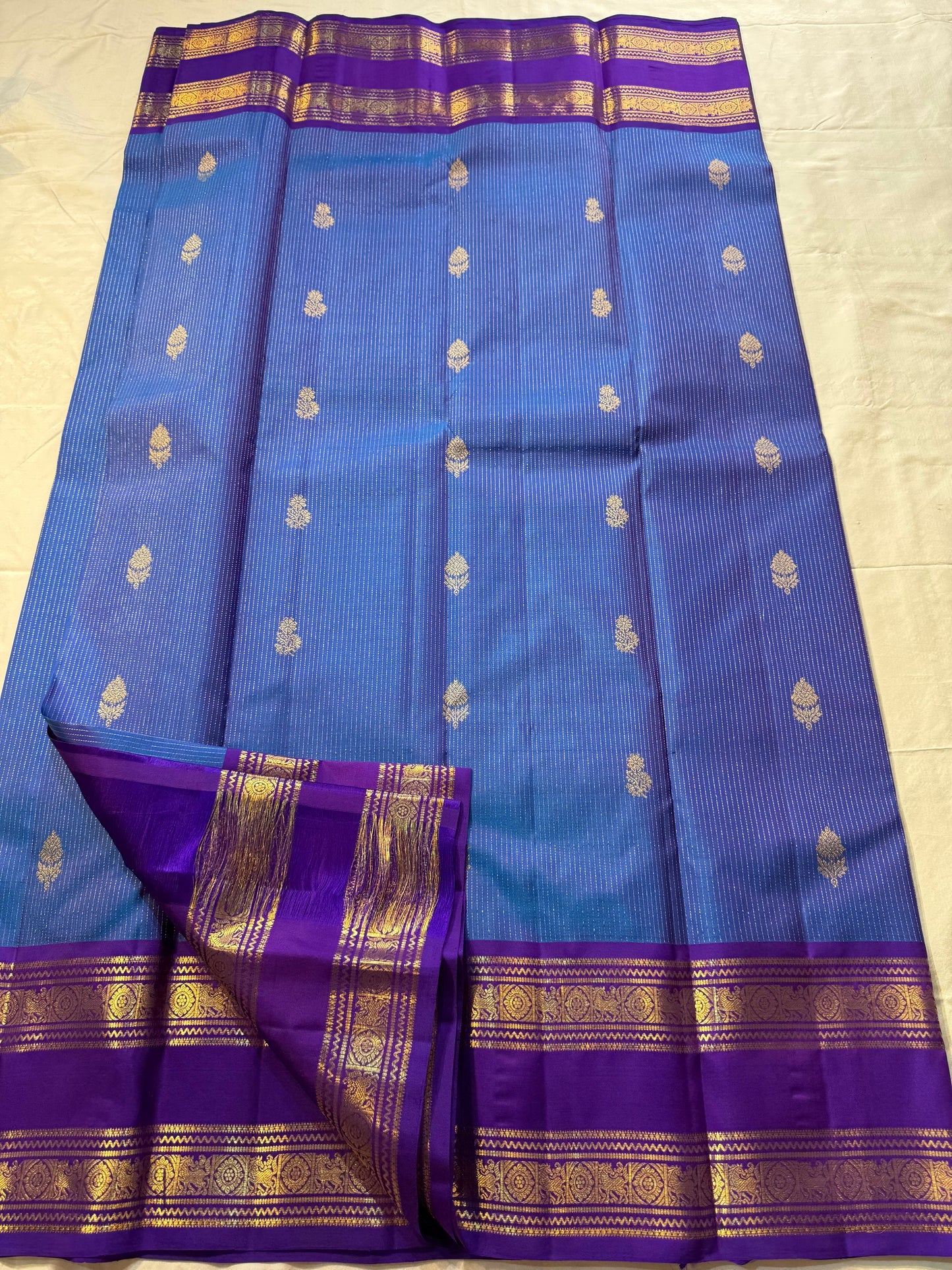 Azure Blue Purple Horizon – Neelam blue body with royal-purple korvai borders  Pure Kanchipuram silk • manga (paisley) buttas + fine pin-stripes  Opulent purple brocade pallu • contrast blouse with zari border  Silk Mark Certified | Fall & Pico Done |