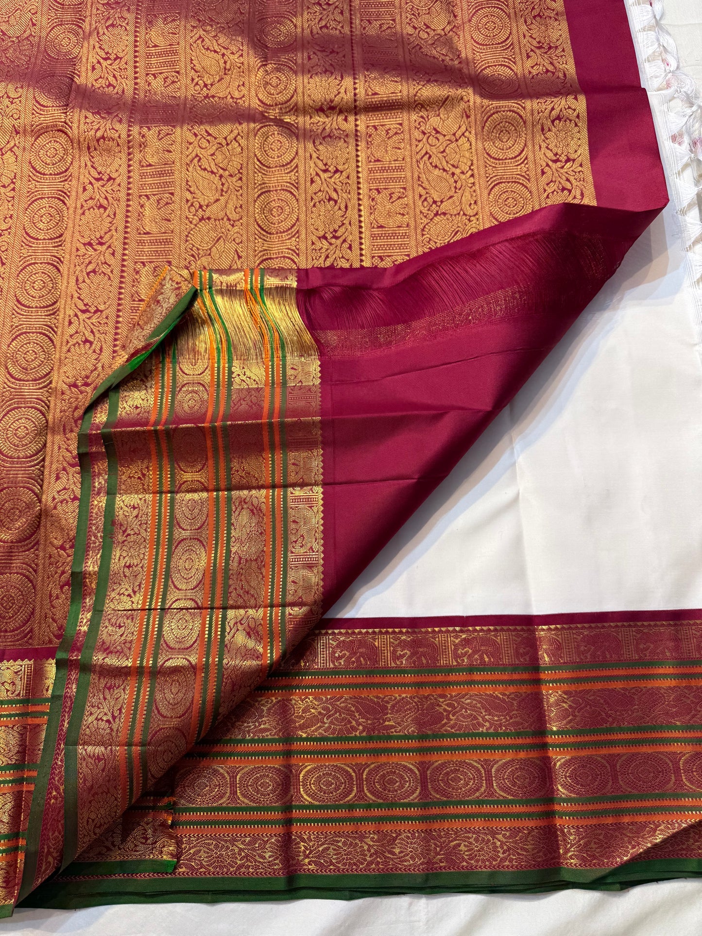 Shveta Chakram — Ivory Kanchipuram Pure Silk 🤍
Contrast maroon brocade pallu & temple border ✨
Chakra medallions, floral vines + green selvedge 🌿
Orange pin-stripes on the border; tasselled finish 🪔
Silk Mark Certified • free shipping with Usa with