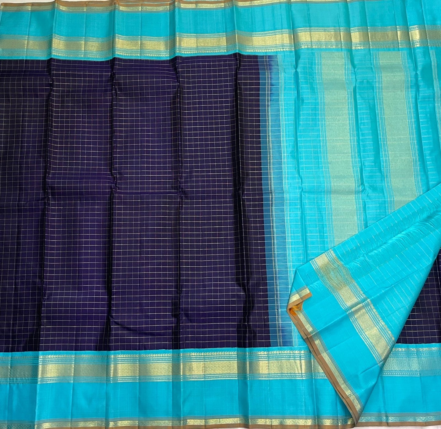 Indigo Teal Kattam – Pure Silk Kanchipuram Saree
Deep Indigo Body with zari Kattam Checks
Teal Contrast Korvai Border with maanga pet and mayil kann border, maanthulir selvedge , silk mark certified -ships in two weeks