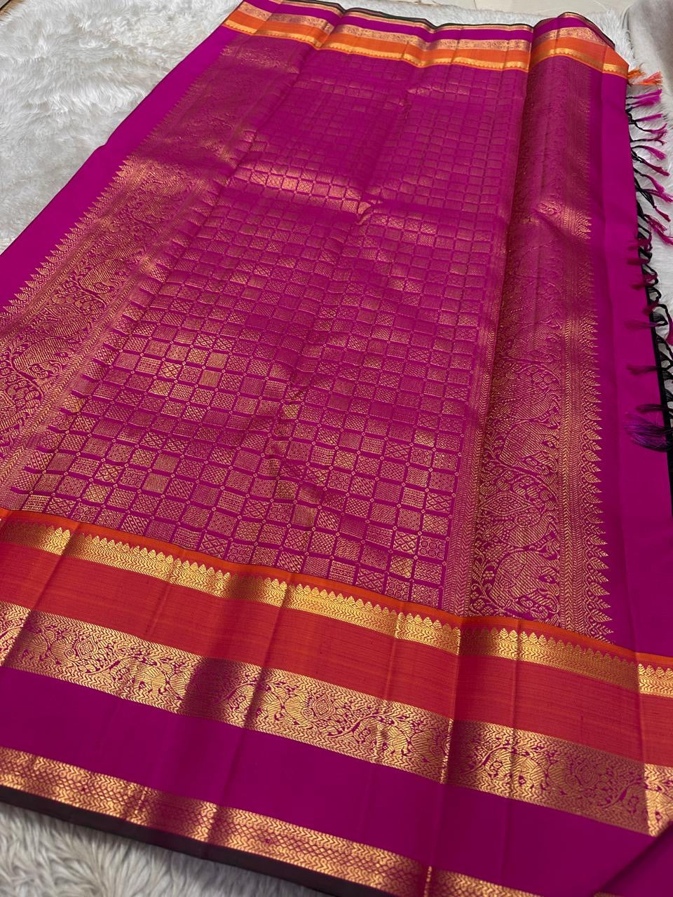 Kanmani — Black & Rani Pure Silk Kanchipuram Saree
Inky black body with gold medallion & peacock buttas
Striking rani-pink and kavi-orange korvai borders with temple-edge zari
Rich rani-pink brocade pallu with grid jaal & heritage vines
Silk Mark Cert