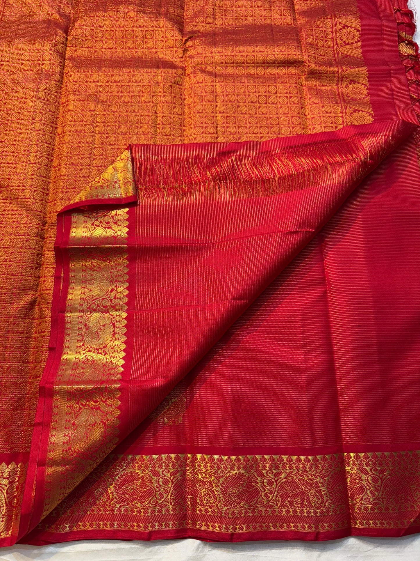 Thilakam Red Vairaoosi — Pure Silk Kanchipuram Saree
Radiant vermilion-red body with gold vairaoosi pinstripes and paisley buttas, paired with a fiery orange-red brocade pallu and grand peacock–elephant zari border ✨
Silk Mark Certified • Fall & Pico Done