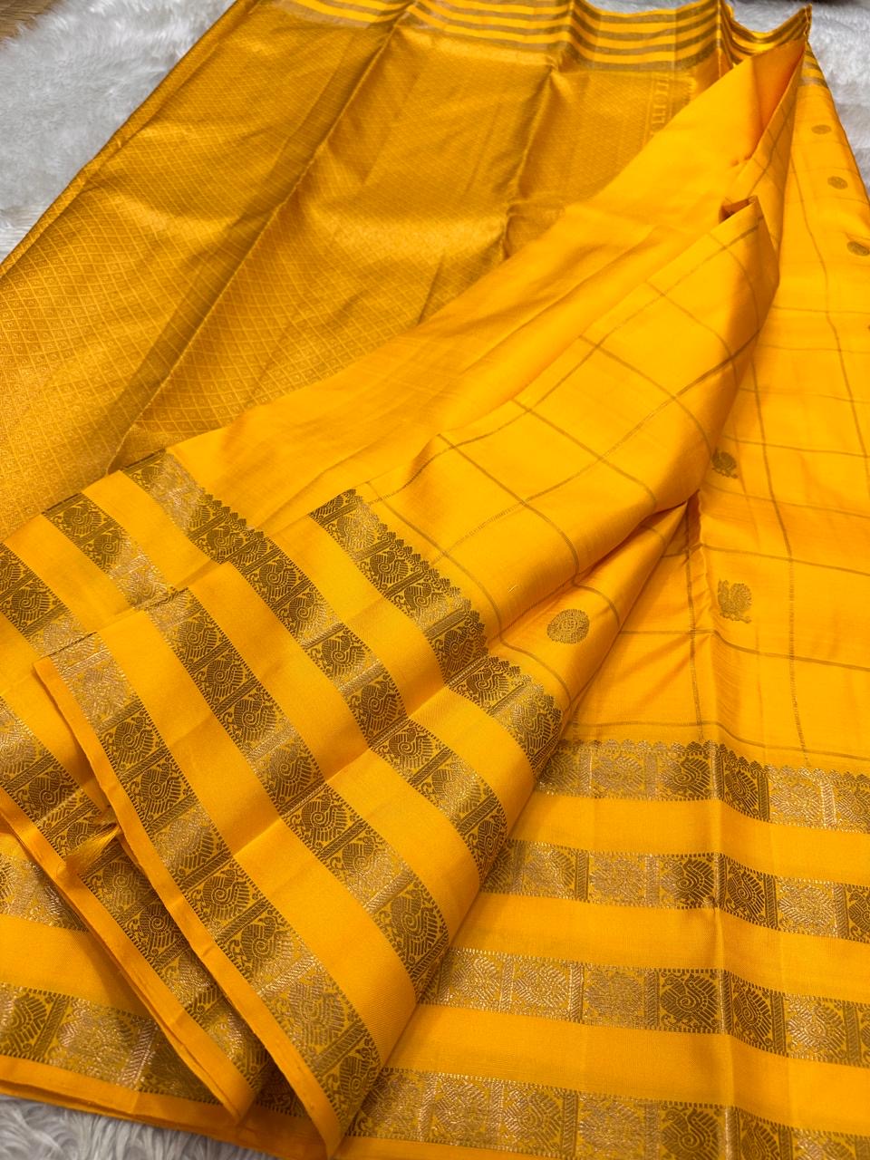 Kanaka – Sunlit Mustard Kanchipuram Silk Saree with Checked Zari Buttas and Gold Striped Border
A radiant weave that captures the warmth of tradition and the glow of celebration