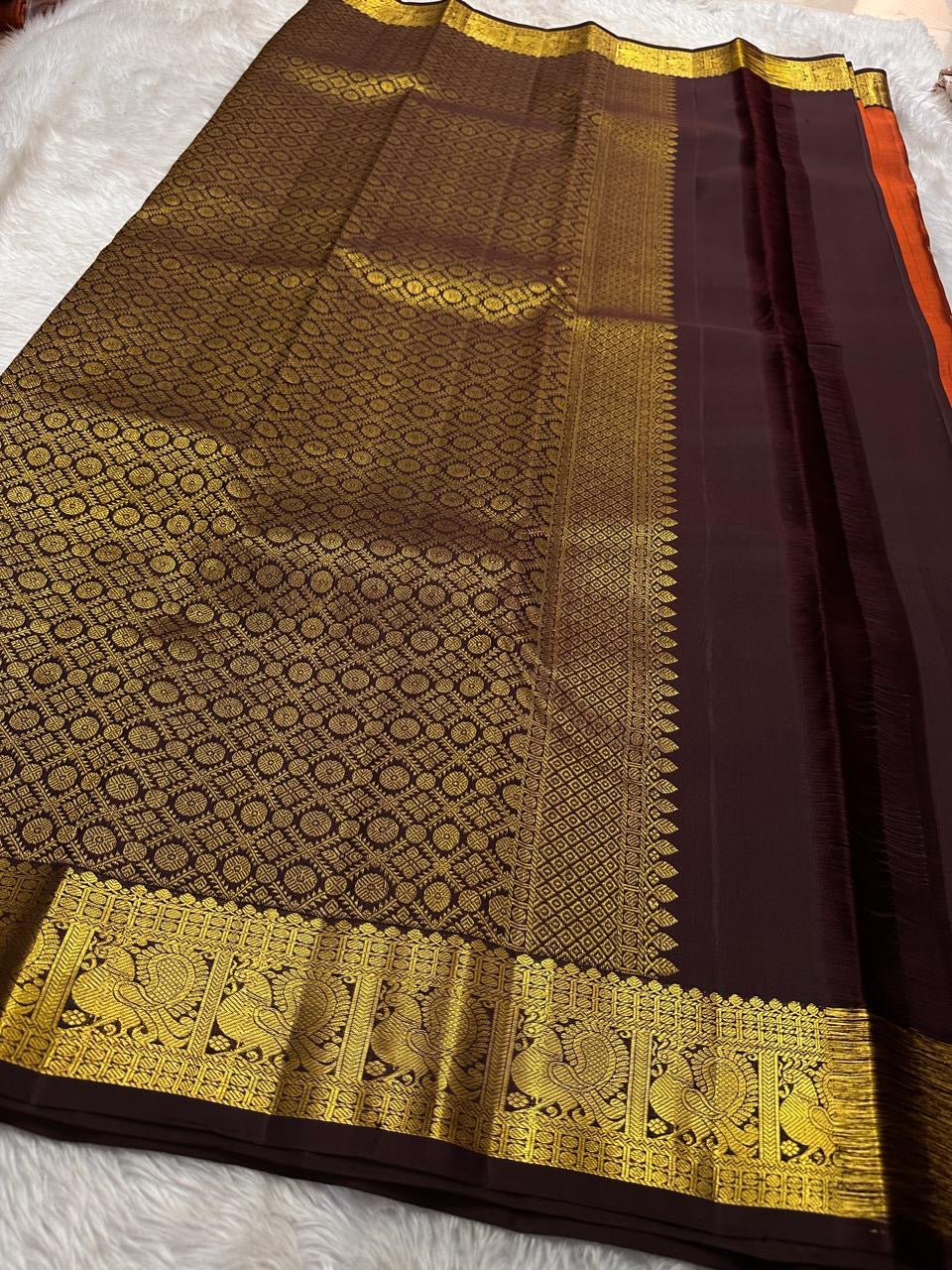 Rust Orange Paisley — Pure Silk Kanchipuram Saree
Rust-orange body with gold coin buttas & grand paisley motif, deep coffee borders with peacock zari panels & temple edge.
Rich zari pallu, contrast blouse; Silk Mark Certified ✅ Free USA Shipping 🇺🇸 Ship