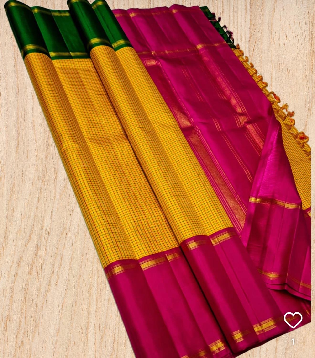 Swarna Kattam Ganga Jamuna — Pure Silk Kanchipuram Saree
Golden mustard kattam checks body • Dual korvai borders in rani pink & emerald green
Rich zari pallu with radiant festive sheen
Contrast emerald blouse with zari selai finish
Silk Mark Certified •