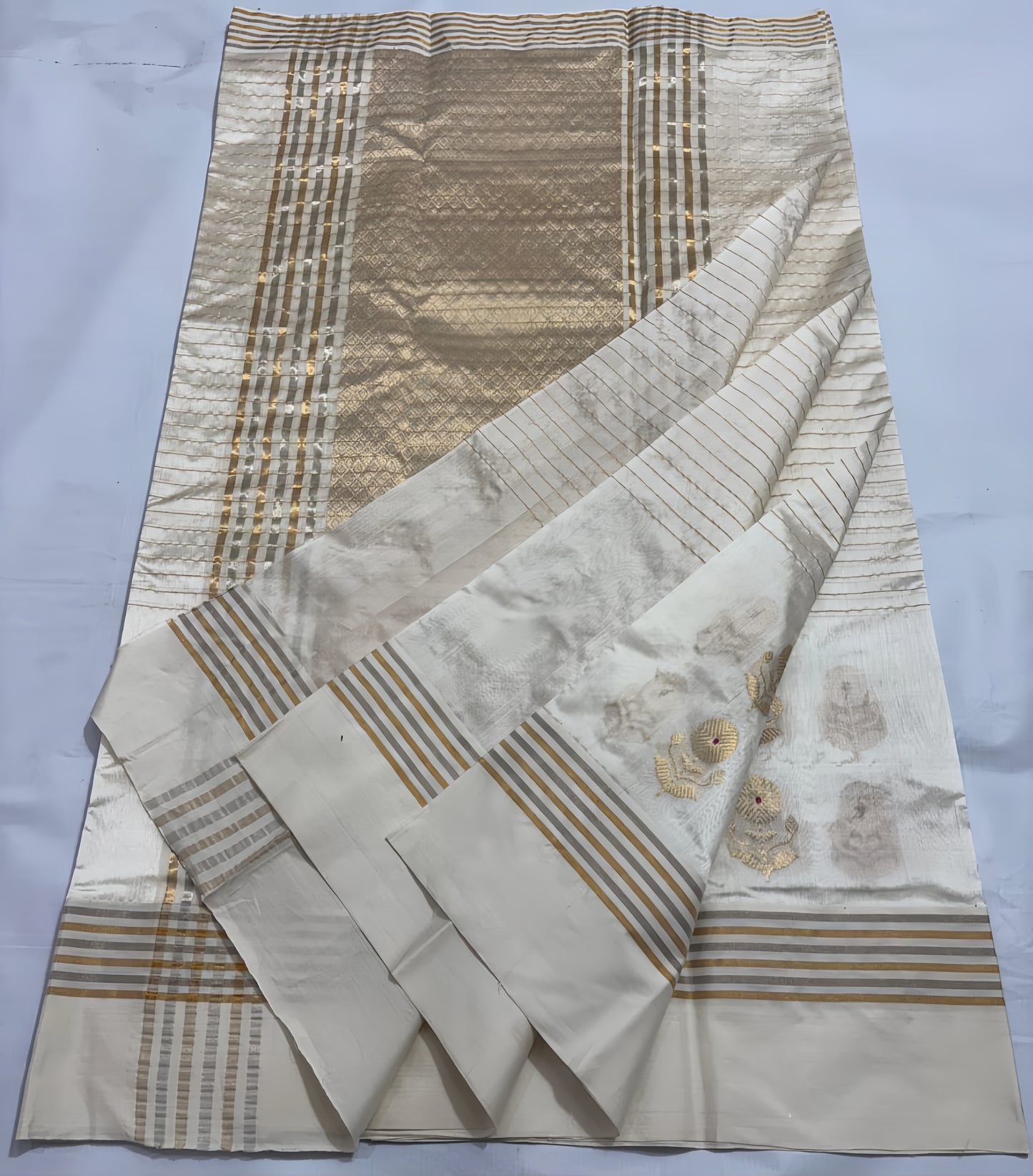Ivory Cream Chanderi Saree with Gold Zari and Handwoven Sunflower Motifs.
A serene blend of tradition and elegance, with intricate red mina accents. Finished with alternating sona roopa stripes and a richly woven pallu for timeless festive charm