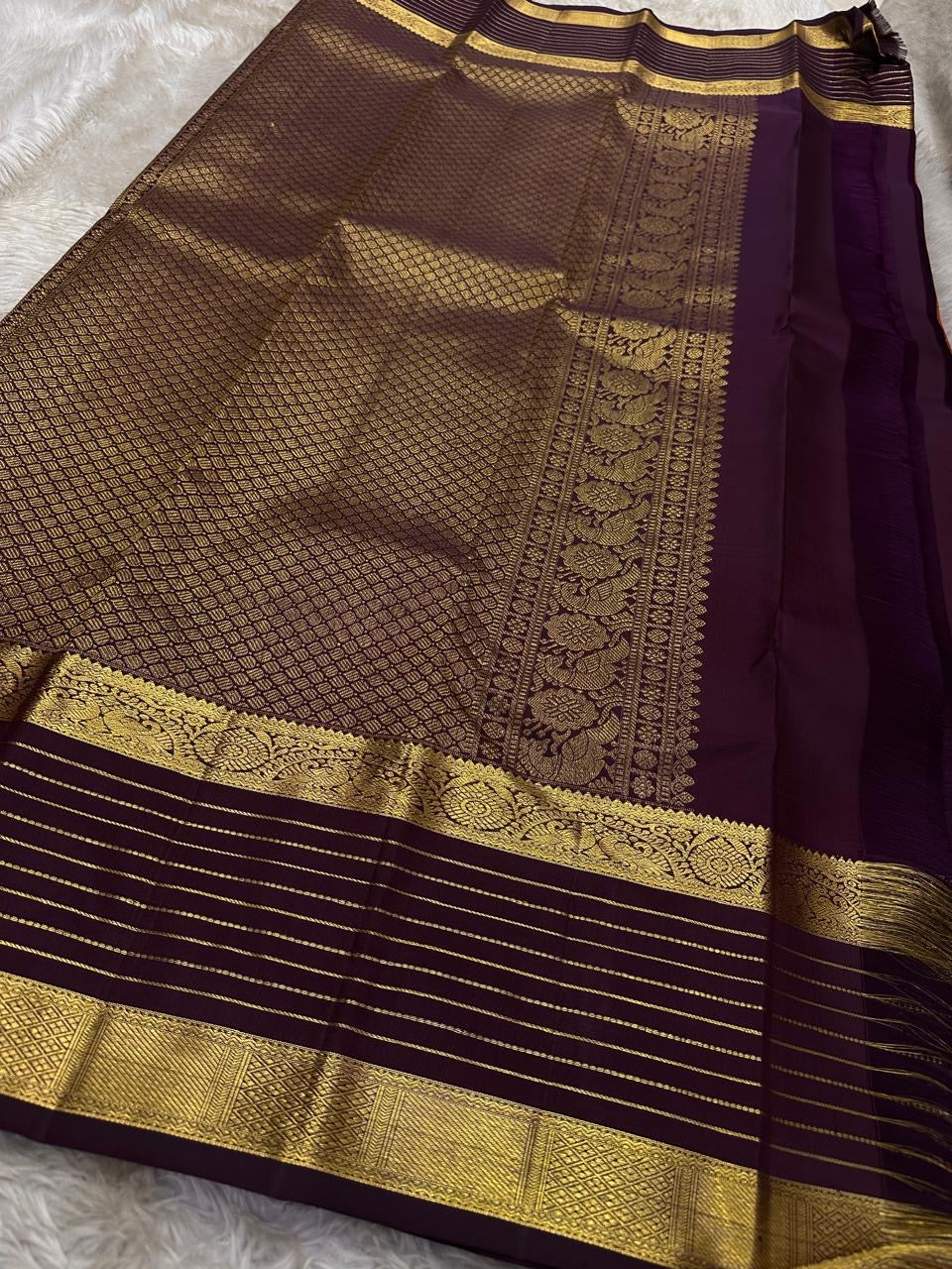 Cinnamon Kattam – Pure Kanchipuram Silk Saree
Vermillion red body with gold kattam checks & floral buttas
Contrast plum purple korvai borders with rich zari weave
Grand zari pallu with lattice & floral motifs in gold
Silk Mark Certified ships in 2weeks