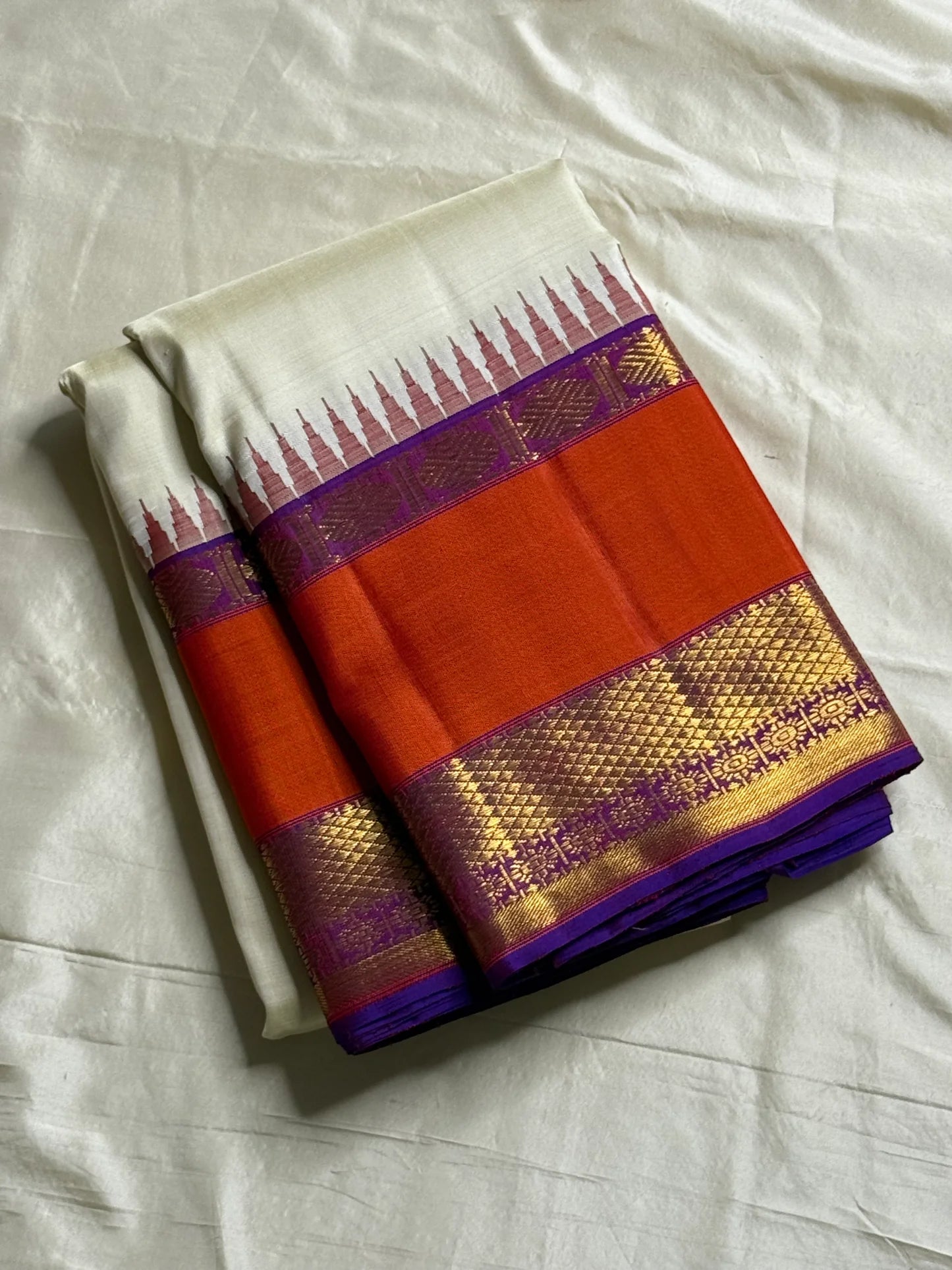 Ivory Temple Glow – Pure Kanchipuram Silk Saree
Ivory Body with Saffron Temple (Gopuram) pillayar moggu
Amethyst-Purple Zari Border with Floral Vines 🌸
Grand Purple Pallu in Rich Zari
Silk Mark Certified, delivery in 2 weeks