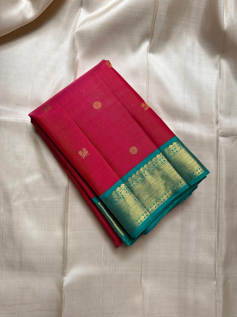 A Very unusual raspberry pink and teal vairaoosi pure silk Kanchipuram Mayil and coin zari buttas all over the boat on top of the zari stripes ! Detailed mayil paisley chakram grid pattern on Pallu 💕