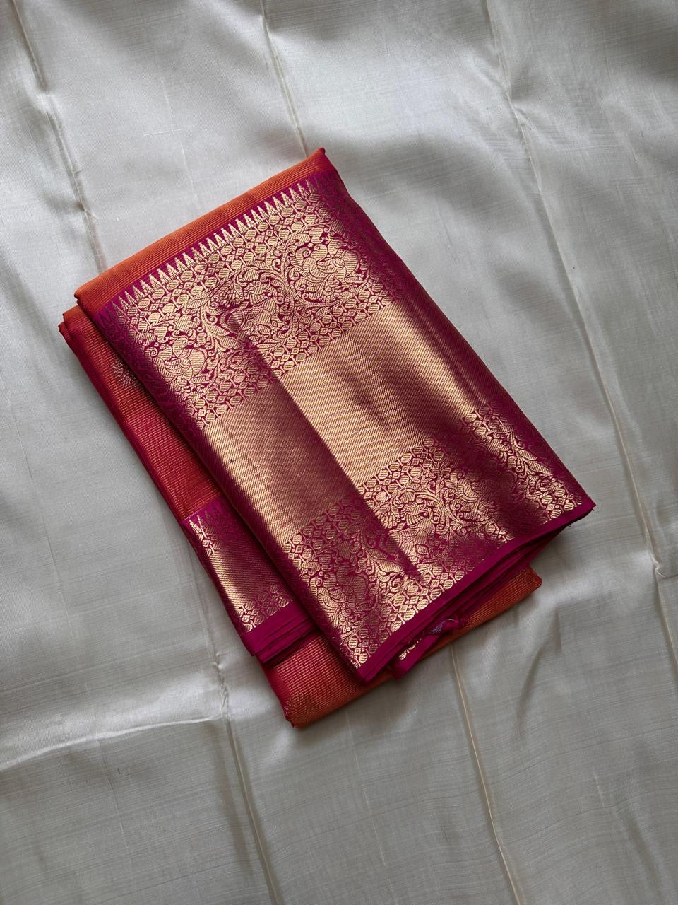 Vairaoosi - silk Kanchipuram thanga velli ( sonaroopa) zari butta in a mesmerizing rust red korvai getti (thick ) zari border with mayil motif