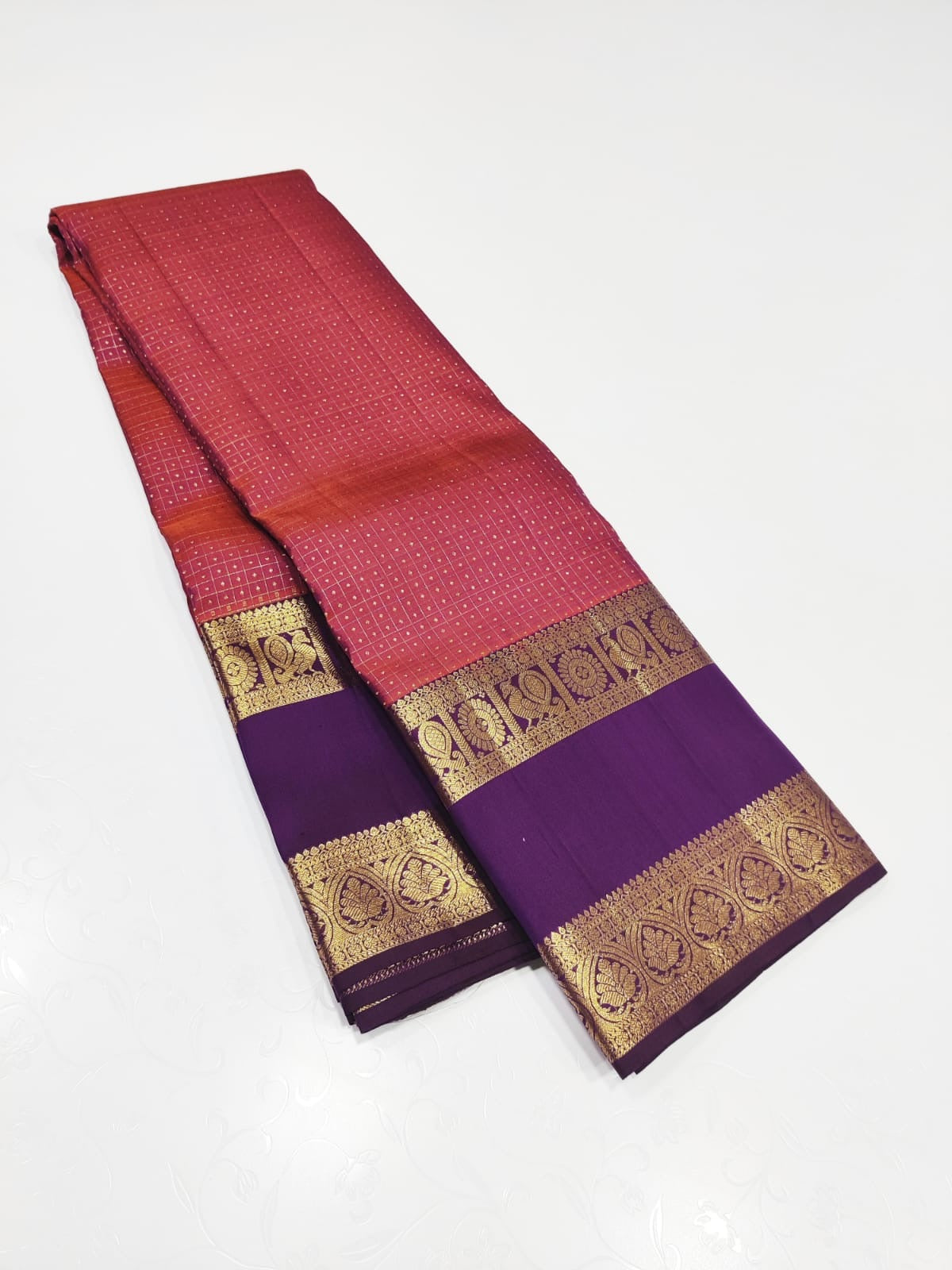Crimson Amethyst – Pure Kanchipuram Silk Saree
Radiant crimson red body woven with delicate gold kattam checks at Iran buttas ✨
Paired with rich amethyst purple korvai borders in ornate zari
Grand brocade pallu Silk Mark Certified, delivery in 2 weeks