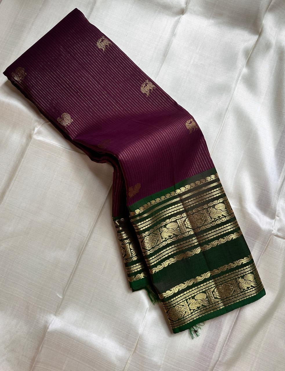 Radhe ✨
Plum Purple Oosi-Striped Kanchipuram Silk
Zari-Woven Yaali Motifs on the Body
Bottle-Green Rettapet Border with Peacocks
Grand Gold Zari Jaal Please | Silk Mark Certified