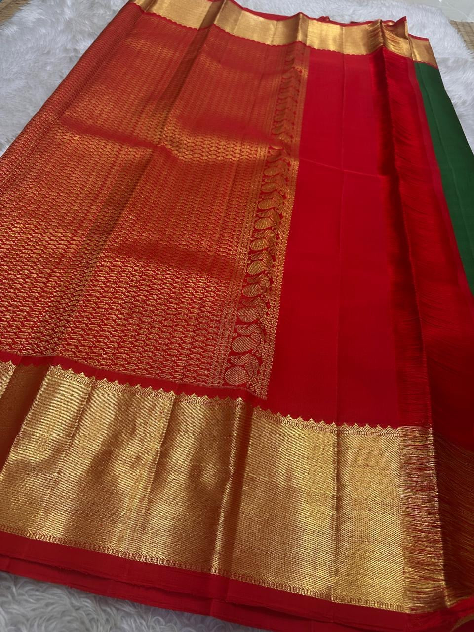 Full spread emerald green Kanchipuram silk saree with red border and grand gold zari pallu