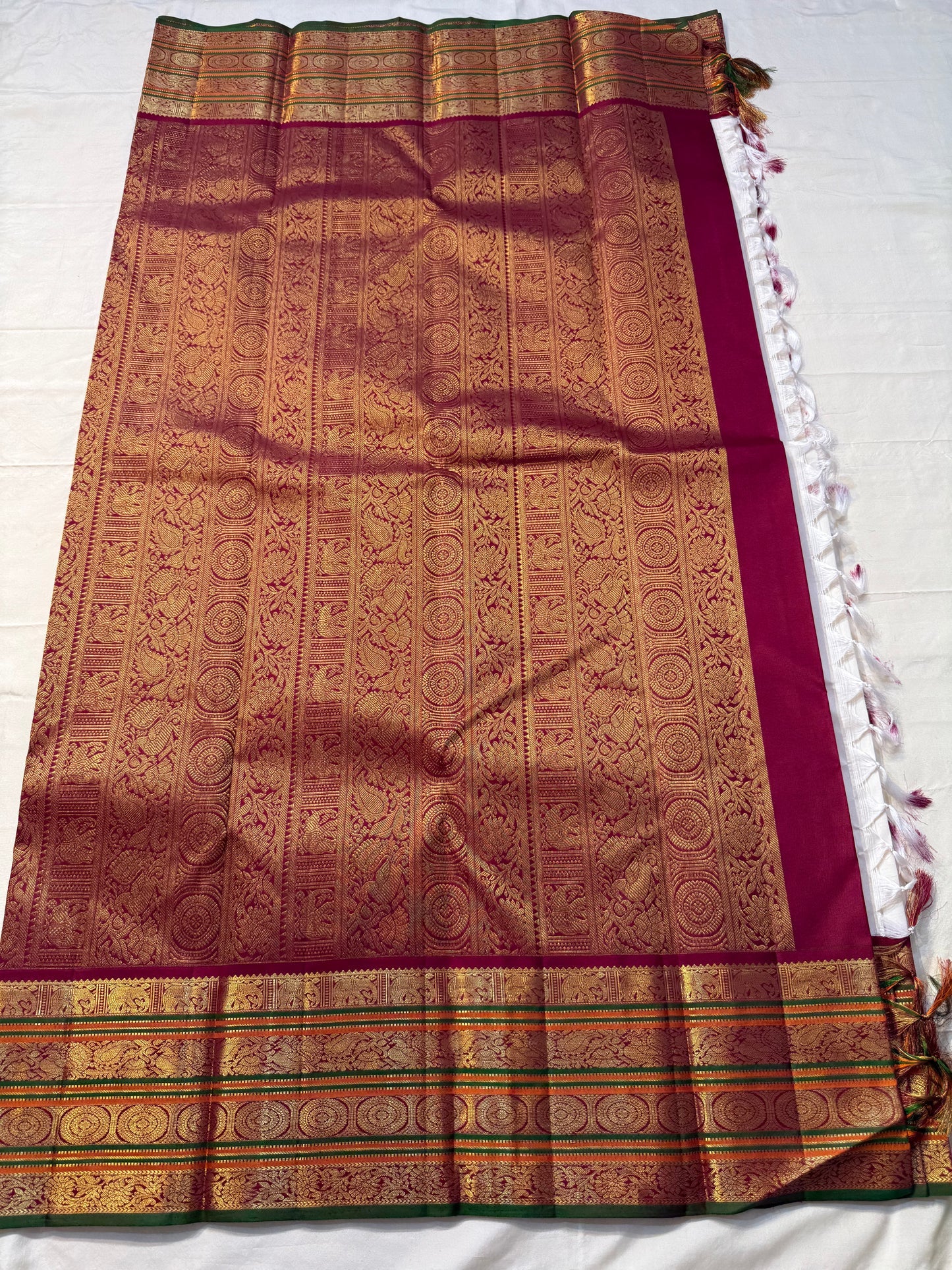 Shveta Chakram — Ivory Kanchipuram Pure Silk 🤍
Contrast maroon brocade pallu & temple border ✨
Chakra medallions, floral vines + green selvedge 🌿
Orange pin-stripes on the border; tasselled finish 🪔
Silk Mark Certified • free shipping with Usa with