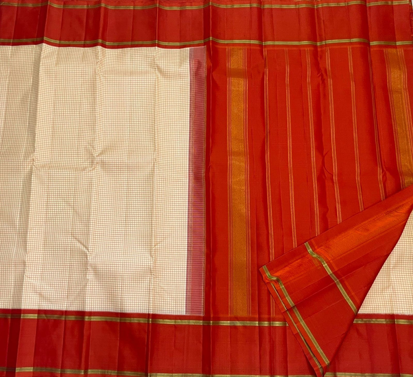 Ivory Vermillion Kattam — Pure Silk Kanchipuram Saree
Buttermilk-Ivory Body with Red Micro-Checks & Vermilion Korvai Border ✨
Gold Pin Lines, Leaf-Green Highlights & Rust Pallu • Silk Mark Certified • Ships in 1 Week ✅