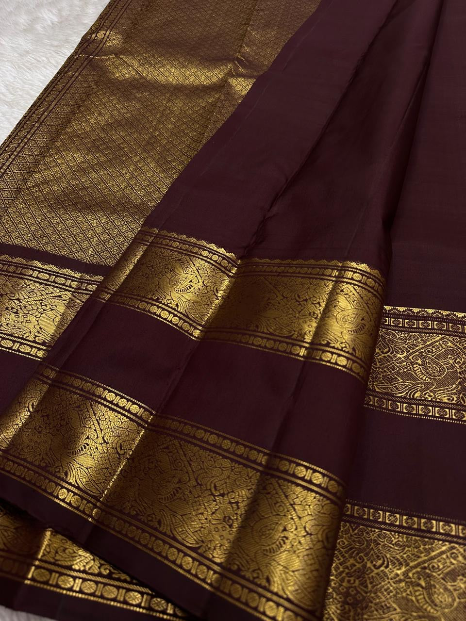 Kasturi 🌰✨
Deep Coffee Brown Pure Silk Kanchipuram Saree
Gold Zari Woven Kamalam & Diamond Buttas All Over
Double Border with Mayil Pettu & Rettapettu Detailing
Diagonal Peacock Pallu with Floral Vine Motifs