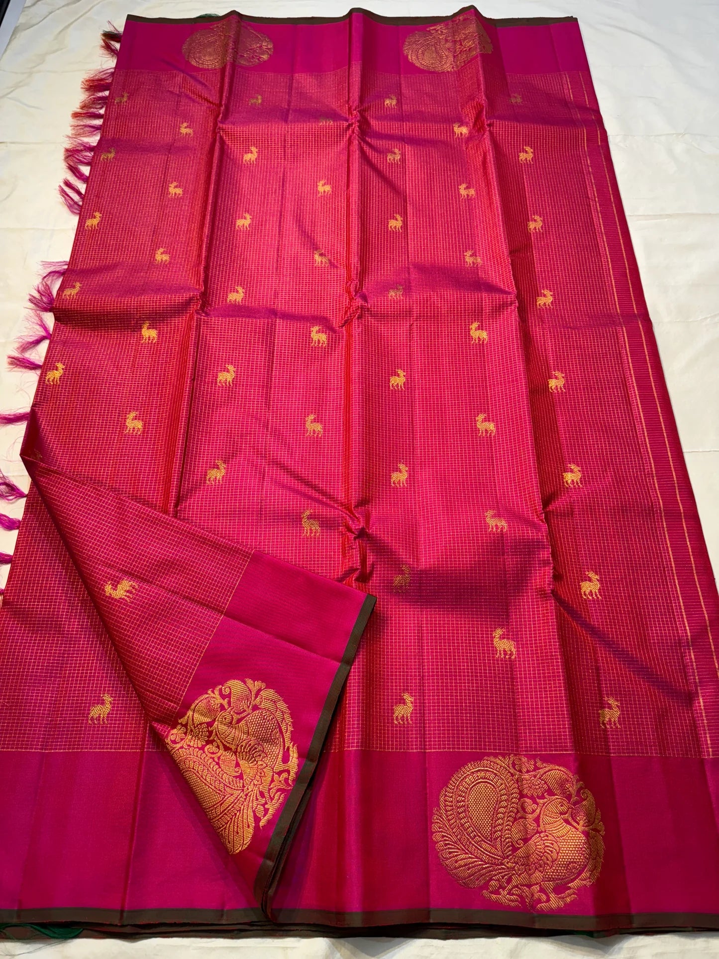 Peacock Arch Zari Kattam — Pure Silk Kanchipuram Saree
Magenta–Rani pink body with fine zari kattam checks & gold peacock motifs • Rust-orange brocade pallu with grand zari weave • Contrast selvedge & rich korvai borders
✨ Silk Mark Cert • Fall & Pico ✅