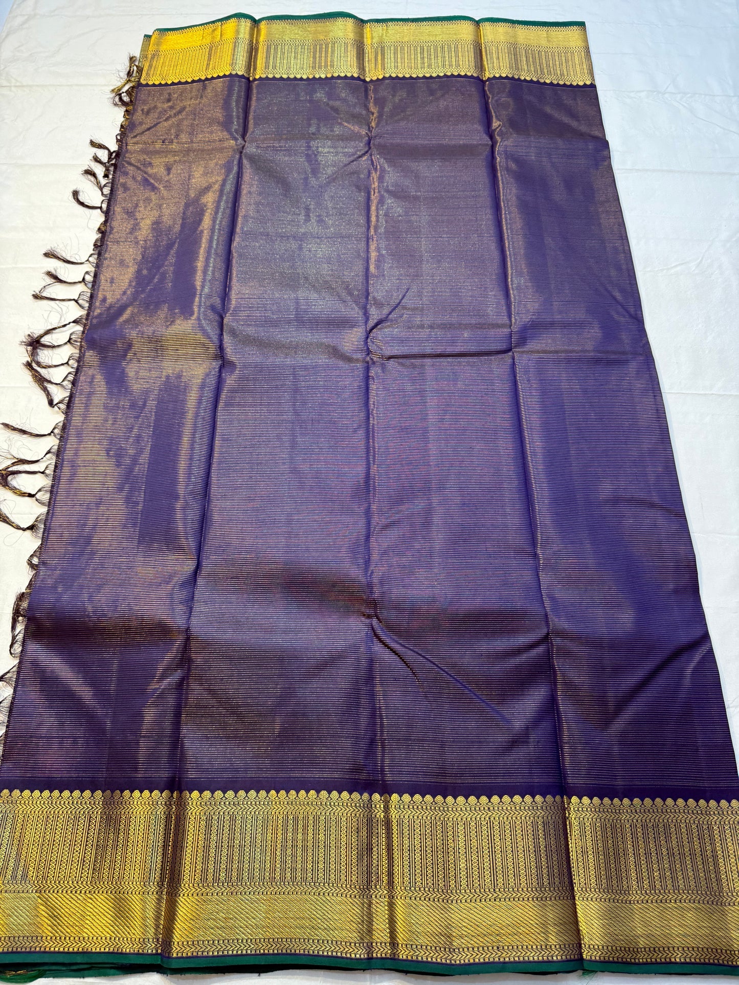 Krishna Shyama — Pure Silk Kanchipuram
Deepest purple “Shyama” body with Vairaoosi pinstripes
Temple-inspired antique gold zari borders with green selvedge
Grand striped zari pallu with hand-tied tassels
Silk Mark Certified • free shipping