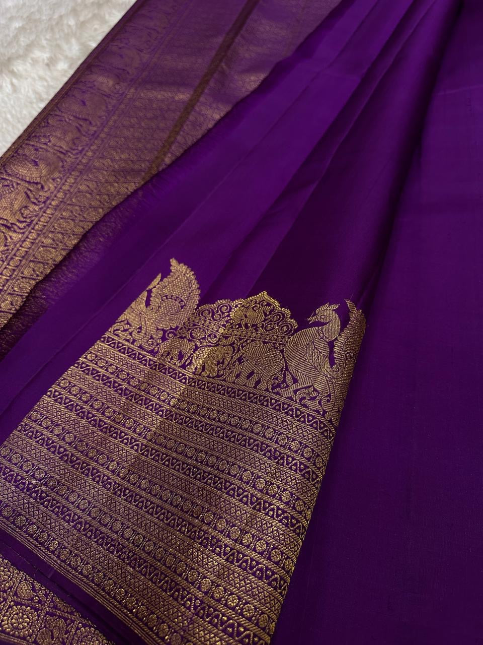 Lotus Glow — Violet | Pure Kanchipuram Silk Saree
A royal violet canvas with antique-gold zari peacocks, elephants & lotus motifs ✨
Silk Mark Certified • Free USA Shipping • Ships in Two Weeks