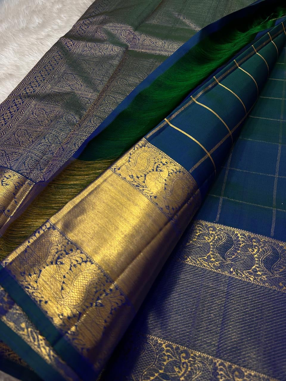 Nemali Zari Checks | Pure Silk Kanchipuram
Peacock-Blue & Emerald-Green Dual Tone • Zari Checks with Buttas
Gold Zari Borders with Paisley Motifs • Rich Brocade Pallu
Silk Mark Certified • Free Shipping within USA
Ships in Two Weeks | Blouse Sti