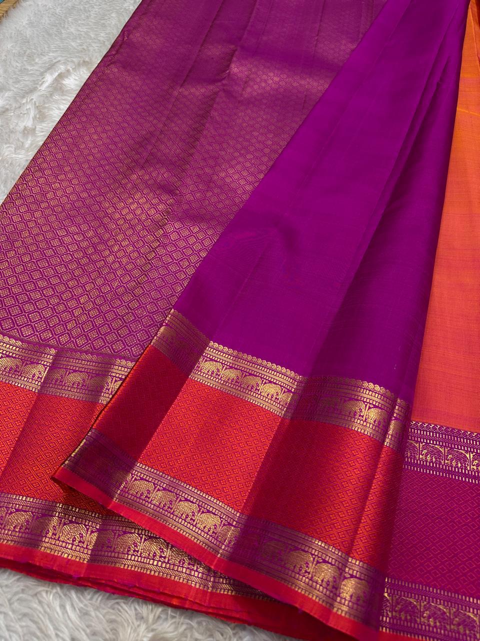 Suryarekha – Pure Korvai Kanchipuram Silk Saree
Kesari-Orange & Pink dual-tone body with gold paisley buttas
Arakku Red korvai border with diamond brocade elephant motifs
Vadamalli Purple grand zari brocade pallu | shios in 2 weeks ,silk mark cer