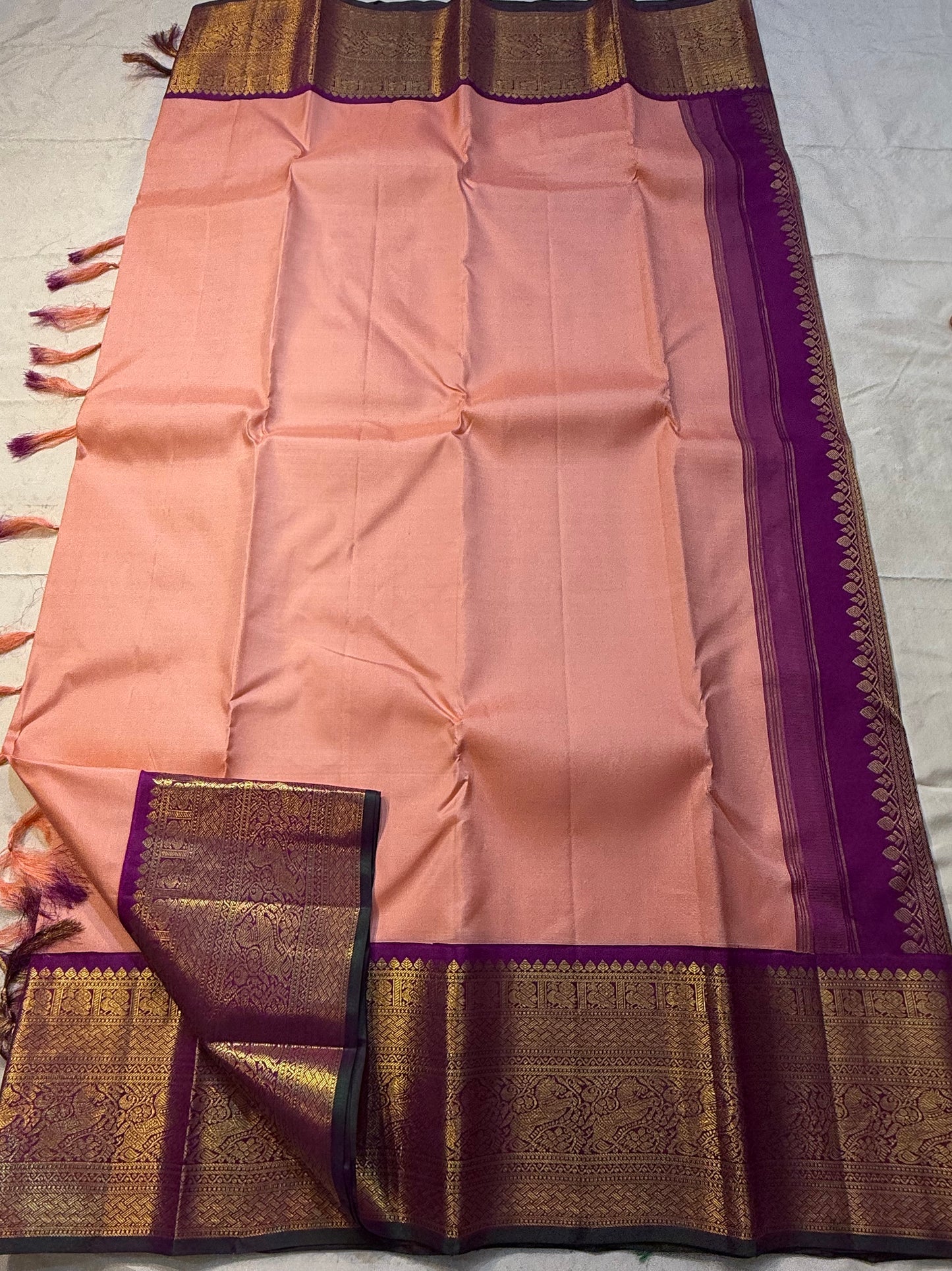 Apricot Yazhi — Pure Silk Kanchipuram Saree
Soft apricot-peach body with royal-purple korvai border featuring antique-gold Yazhi & Mayil motifs and temple edges.
Silk Mark Certified • Blouse Stitching ($30) • Free USA Shipping • Ships in 2 Weeks