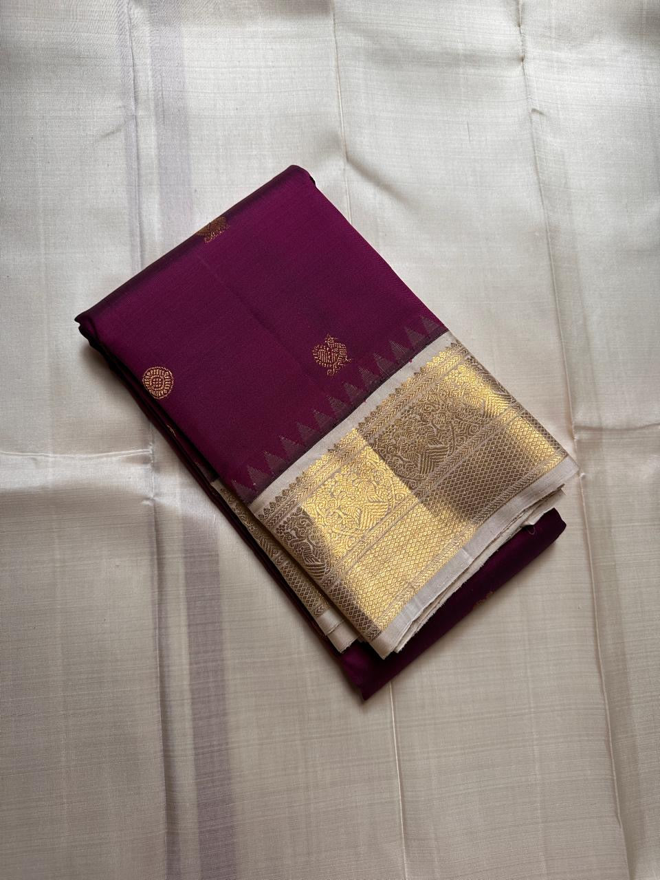 Varuni — Deep Purple & Magenta Shot Kanchipuram Silk Saree
Gold Zari Peacock Motifs on Luxurious Pure Silk
Antique Gold Korvai Border with Gandaberunda Design
Intricate Temple-Inspired Pillayar Moggu Detailing
Silk mark certified