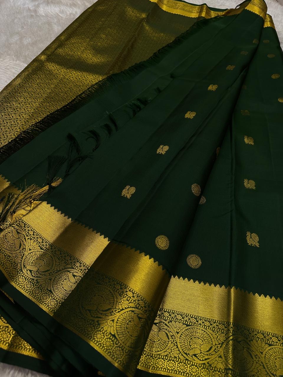Agnika – Green Kanchipuram Silk Saree with Mayil Chakram Butta
Fiery and regal, Agnika features a rich green silk body with intricate Mayil Chakram (peacock) motifs and a shimmering zari border—an elegant ode to South Indian tradition.