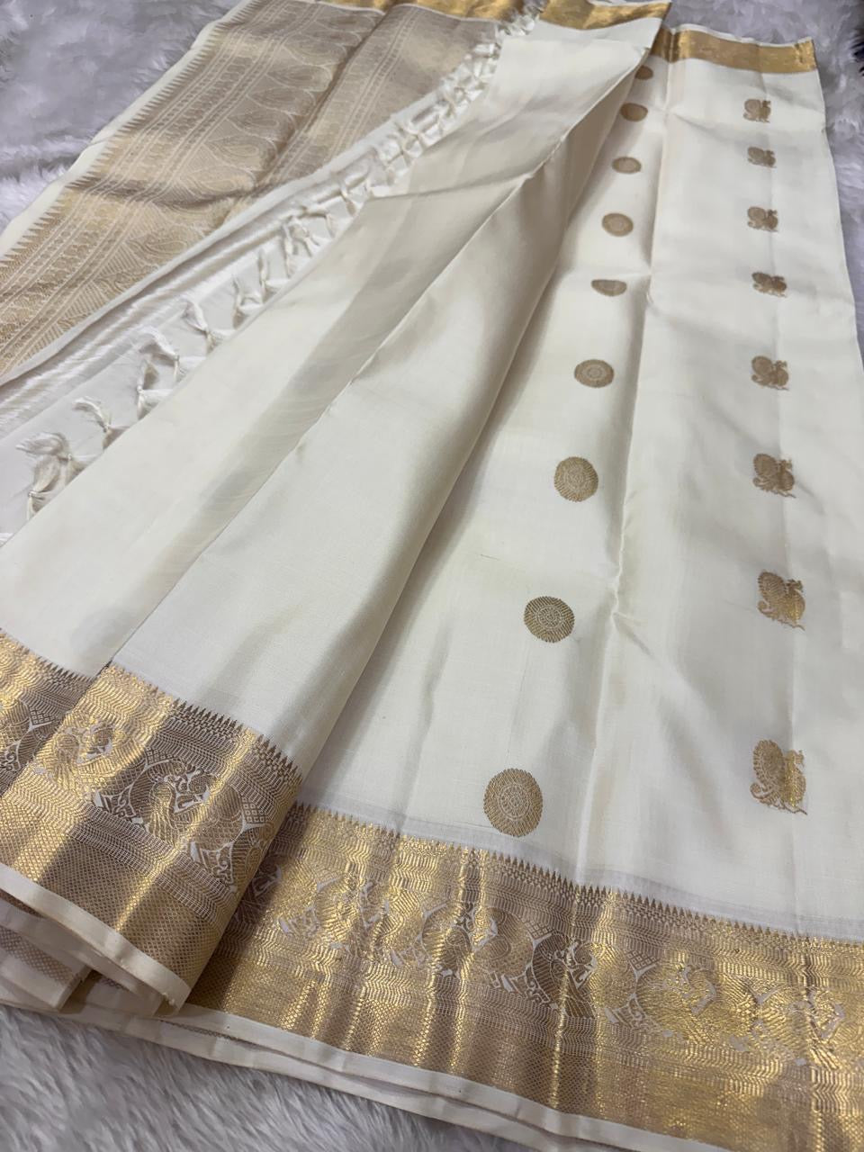 Pearl Radiance ✨ – Pure Kanchipuram Silk Saree
Ivory Body with Gold Zari Buttas & Medallions
Traditional Yali & Peacock Motif Zari Border
Grand Zari Pallu with Paisleys & Floral Vines
Silk Mark Certified | Free USA Shipping