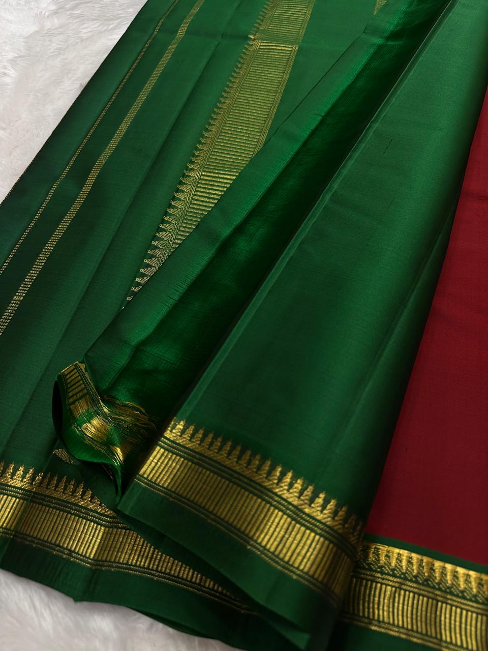 Detail of the Pillayar Reku at the body-border junction — Ganesha motif woven continuously in gold zari on bottle green ground