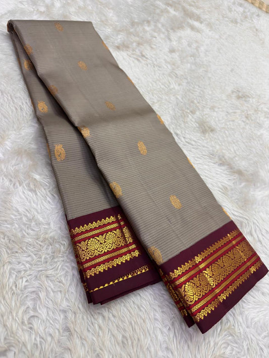 Close view of the steel grey silk body showing fine woven stripe structure and scattered Pavun Butta in gold zari