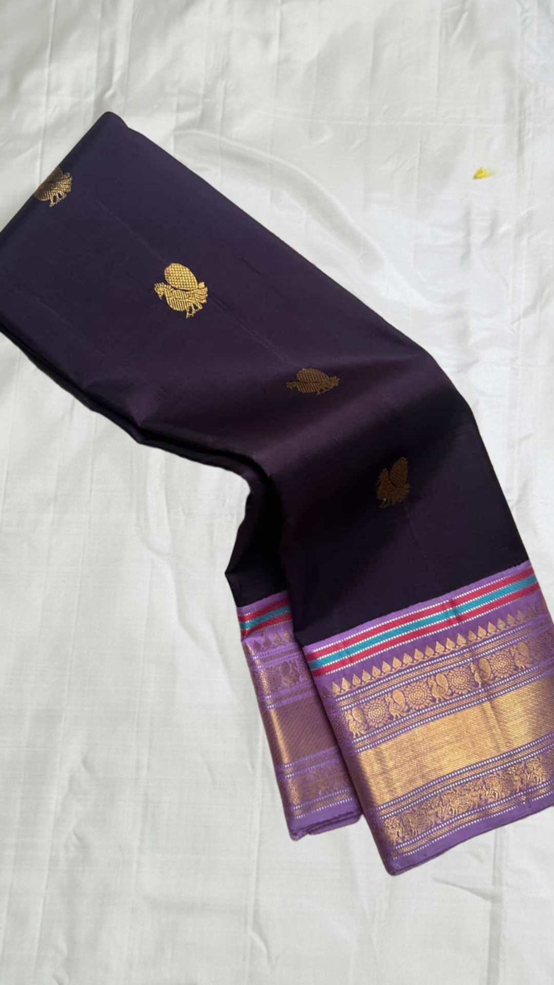 aubergine purple kanchipuram silk saree with gold zari buttas and lavender zari border shown in soft drape