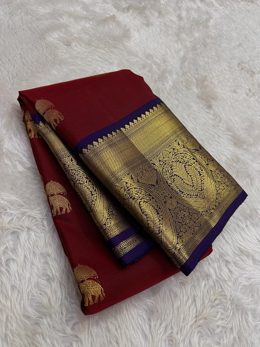 Folded maroon pure silk saree showing gold elephant motifs and oversized paisley border