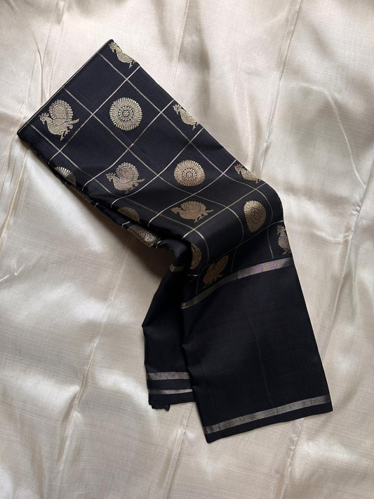 Black Pure Kanchipuram silk saree showing zari woven grid with peacock and circular medallion buttas on the body.