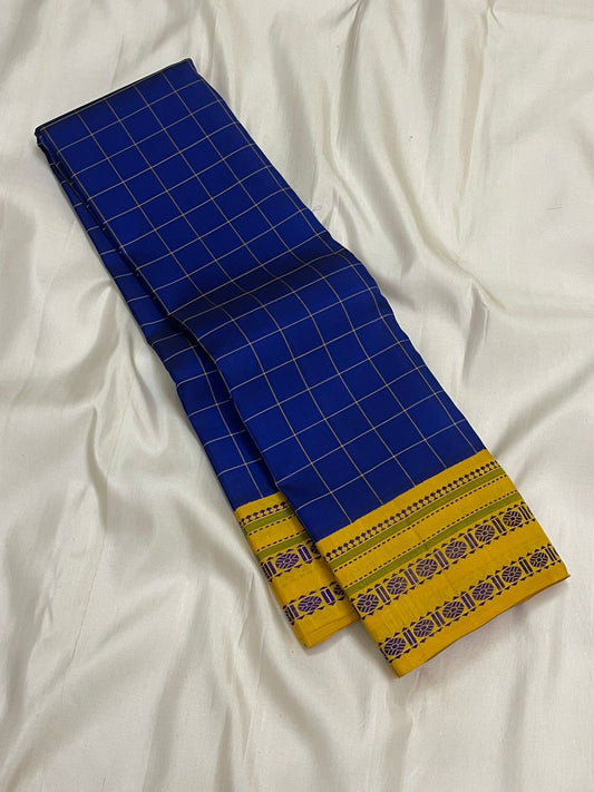 Long folded royal blue checked pure Kanchipuram silk saree showing mustard yellow border detail on white backdrop