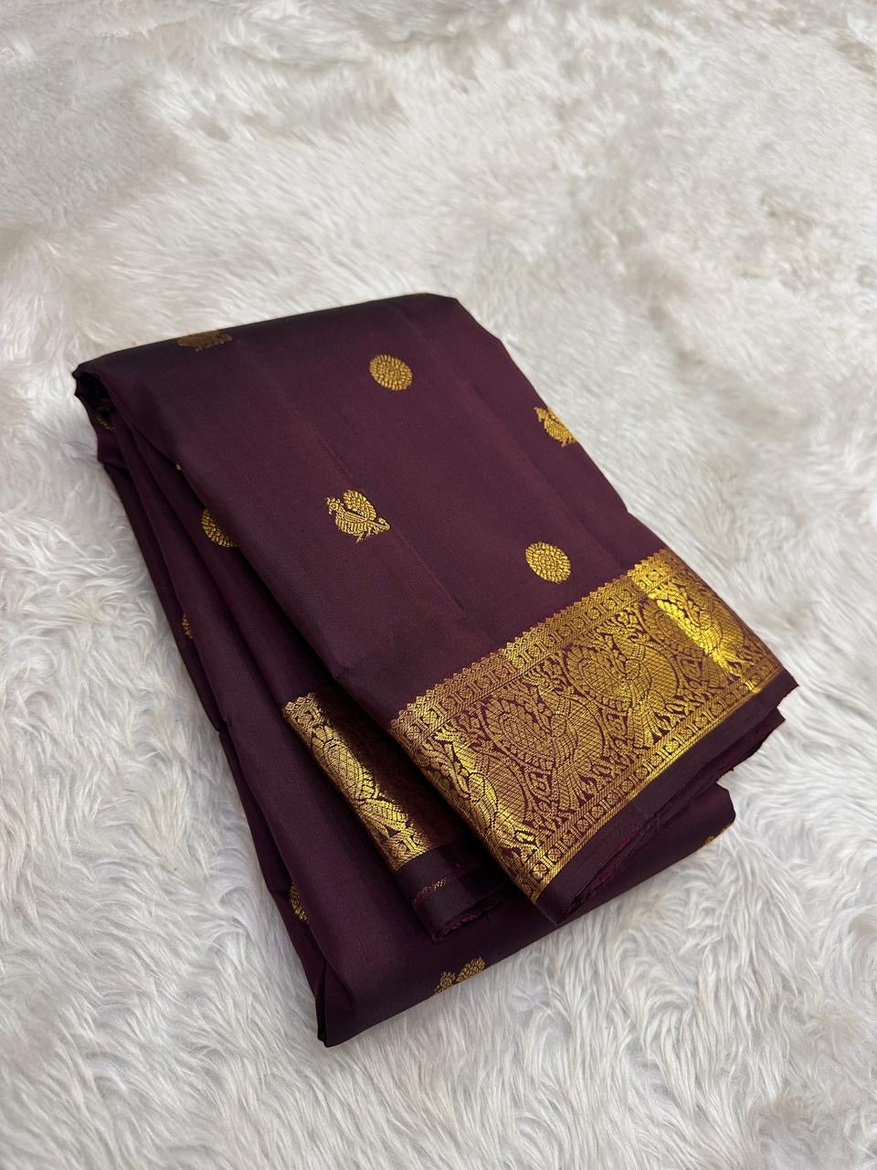 Authentic Kancheepuram silk saree featuring earthy brown silk and luminous antique gold Annapakshi weaving