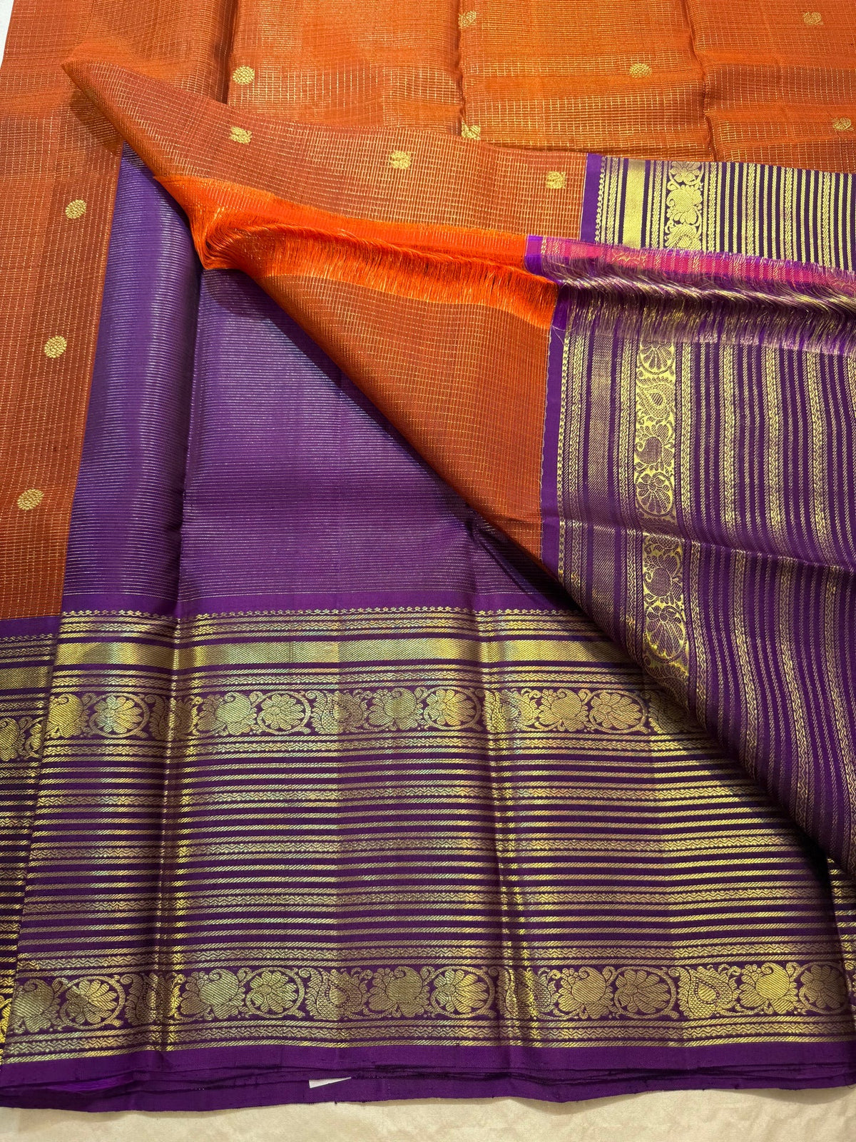 Orange Kanchipuram silk with Mayil Chakram buttas and purple border