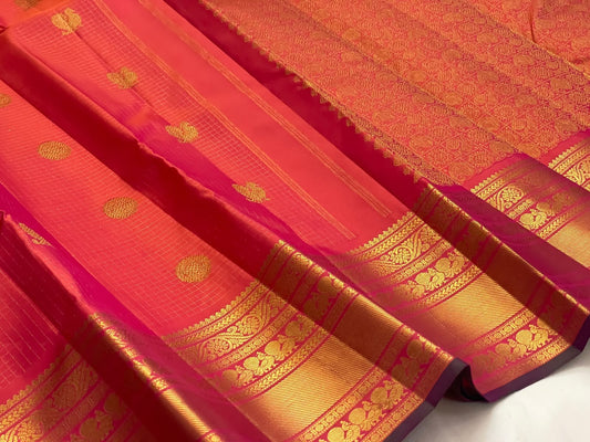 Coral and sunset orange double-shot silk with Zari Kattam checks on a handwoven Kanchipuram saree