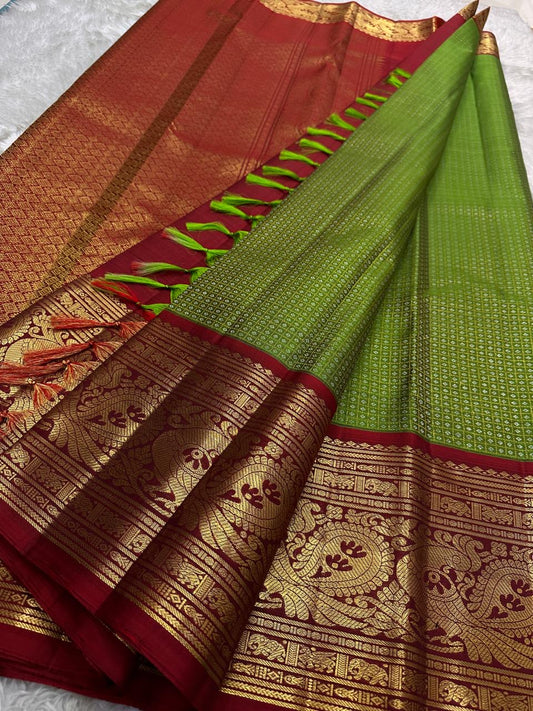 Handwoven Kanjeevaram Korvai saree featuring betel leaf green body and dramatic vermilion red contrast pallu