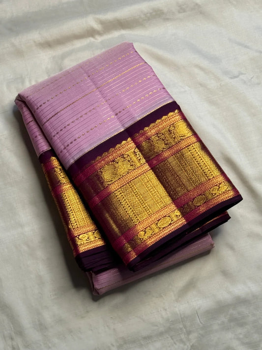 Deep Aubergine Korvai border with raspberry accents and layered gold zari on lavender Kanchipuram saree.