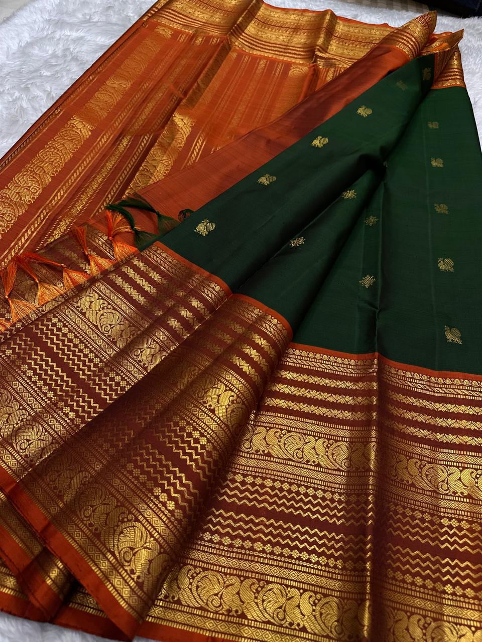 Mayil Butta peacock motif in gold zari on deep forest green Varisaipet body