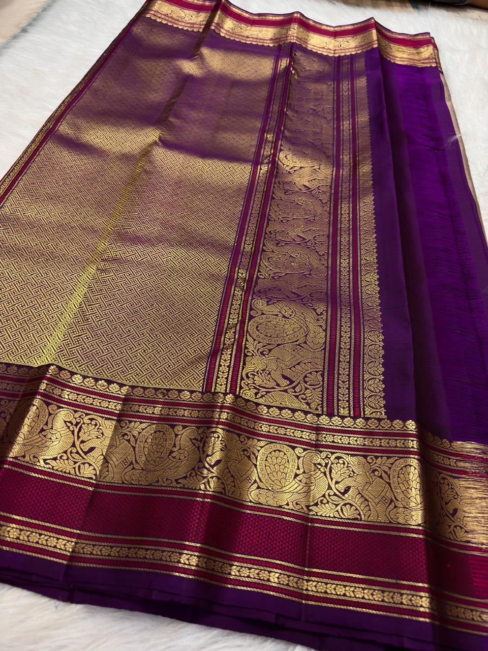 Close view of repeating Mayil gold zari motifs on Deep Purple Varisaipet Kanchipuram border.